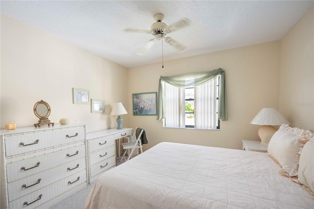 carpeted bedroom with a ceiling fan and a textured ceiling