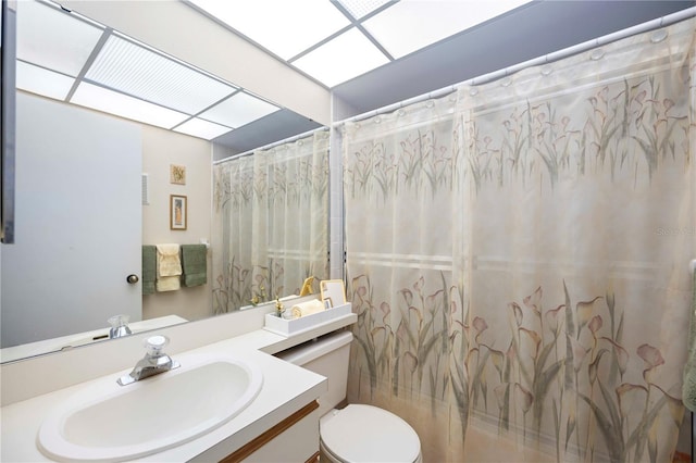 bathroom featuring vanity, curtained shower, and toilet