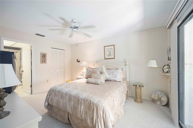 bedroom with visible vents, light carpet, ensuite bathroom, a closet, and ceiling fan