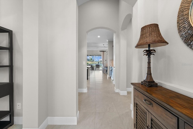 corridor featuring arched walkways and baseboards