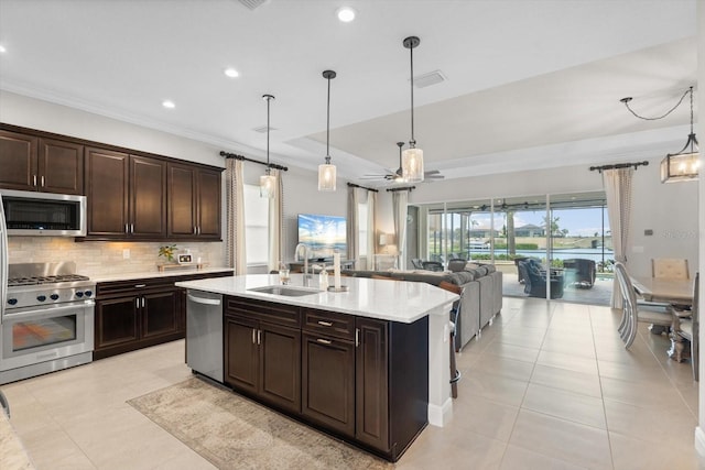 kitchen with crown molding, stainless steel appliances, tasteful backsplash, open floor plan, and a sink