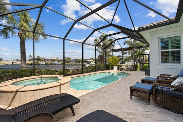 pool with an in ground hot tub, a patio area, and a lanai