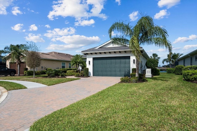 single story home featuring a garage, decorative driveway, a front lawn, and stucco siding