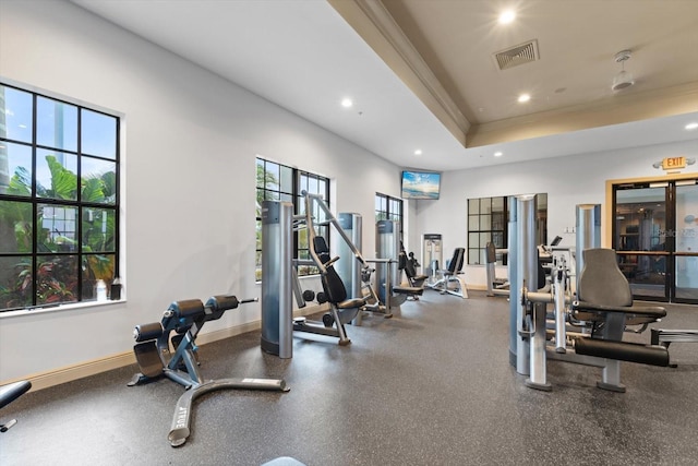 exercise room featuring baseboards, visible vents, a tray ceiling, crown molding, and recessed lighting