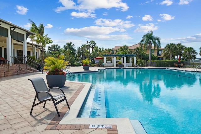 community pool featuring fence, a pergola, and a patio