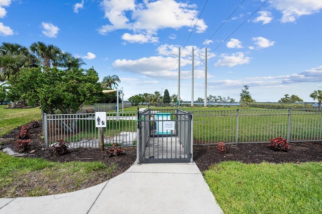 view of gate featuring fence and a yard