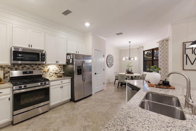 kitchen with stainless steel appliances, white cabinetry, a sink, and backsplash