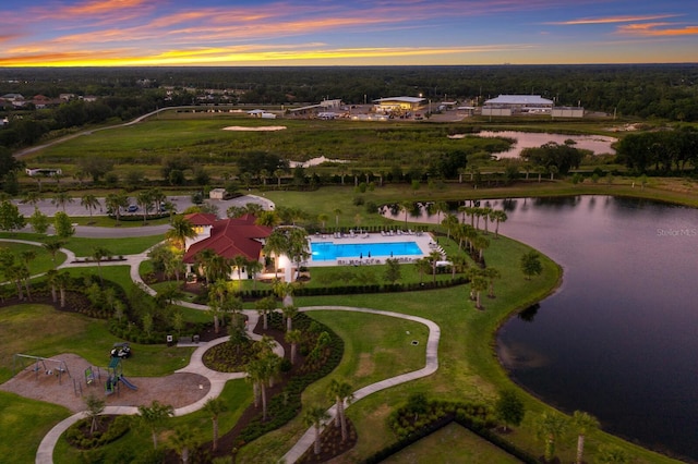 aerial view at dusk featuring a water view