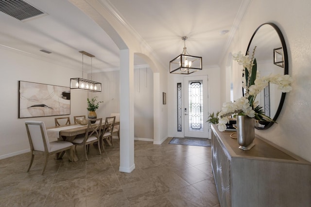 entryway featuring baseboards, visible vents, arched walkways, ornamental molding, and an inviting chandelier