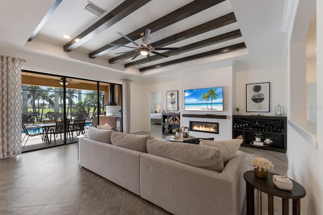 living room featuring ceiling fan, tile patterned flooring, visible vents, beamed ceiling, and a glass covered fireplace