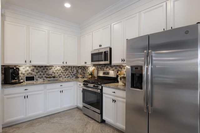 kitchen featuring stainless steel appliances, light stone counters, white cabinets, and decorative backsplash