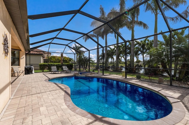 view of pool featuring a patio, a pool with connected hot tub, and glass enclosure