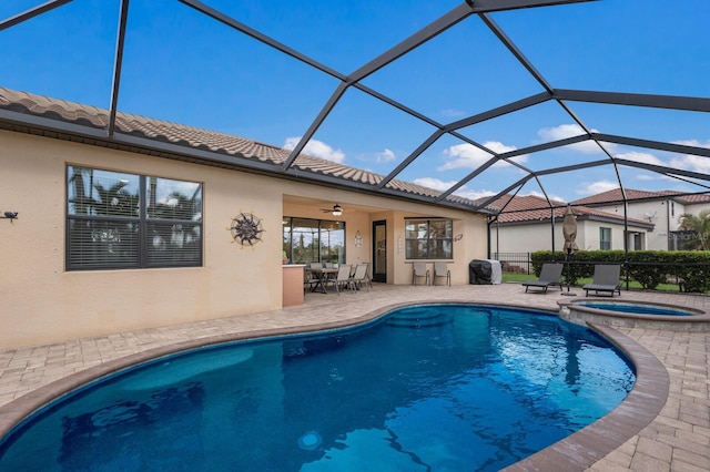 view of swimming pool with a ceiling fan, a pool with connected hot tub, a patio, and a lanai