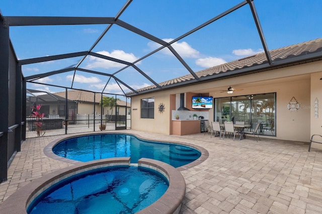 view of pool featuring a pool with connected hot tub, glass enclosure, and a patio