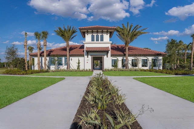 view of front of property with driveway, stucco siding, a front lawn, and a tiled roof