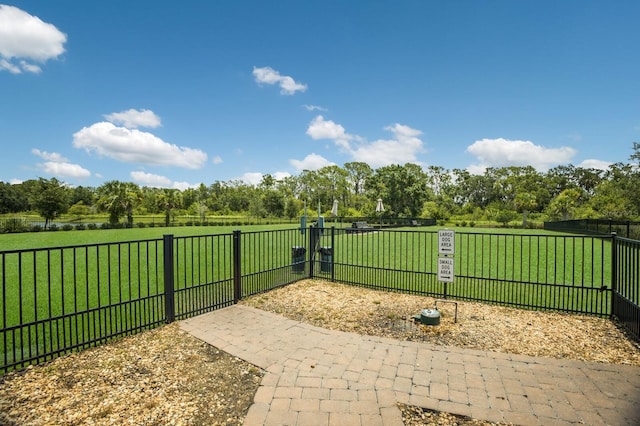 view of gate with a yard and fence