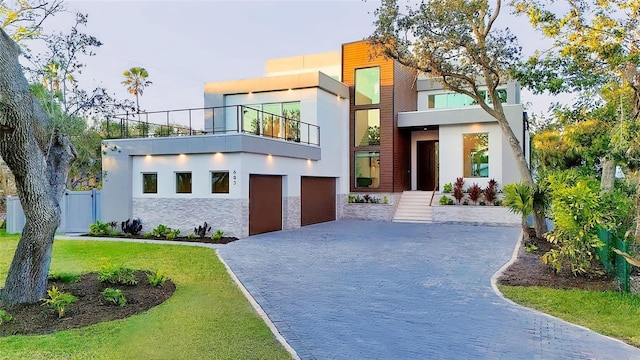 603 Tremont St, Sarasota, FL 34242 - contemporary house featuring a balcony, decorative driveway, stucco siding, a garage, and stone siding
