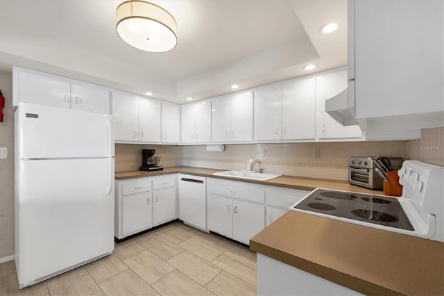 kitchen with white appliances, ventilation hood, a sink, white cabinets, and tasteful backsplash