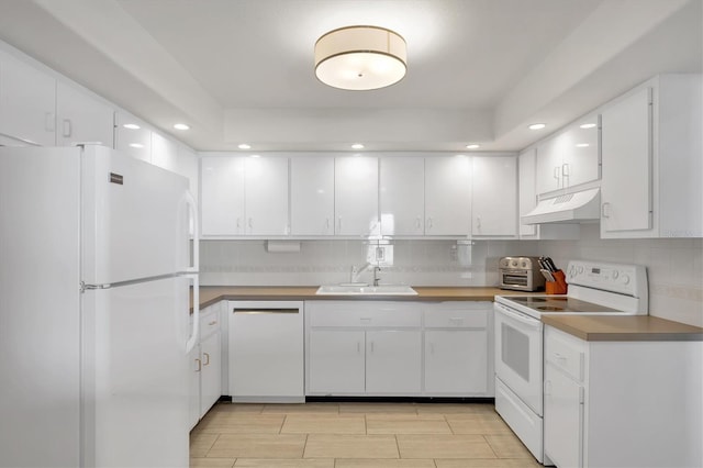 kitchen with white appliances, a sink, decorative backsplash, under cabinet range hood, and white cabinetry