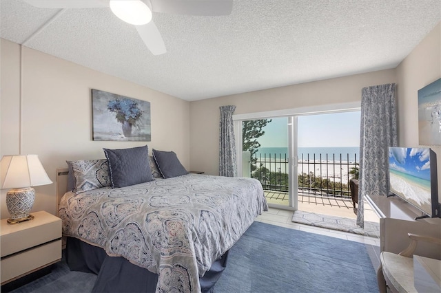 bedroom featuring access to outside, a ceiling fan, and a textured ceiling