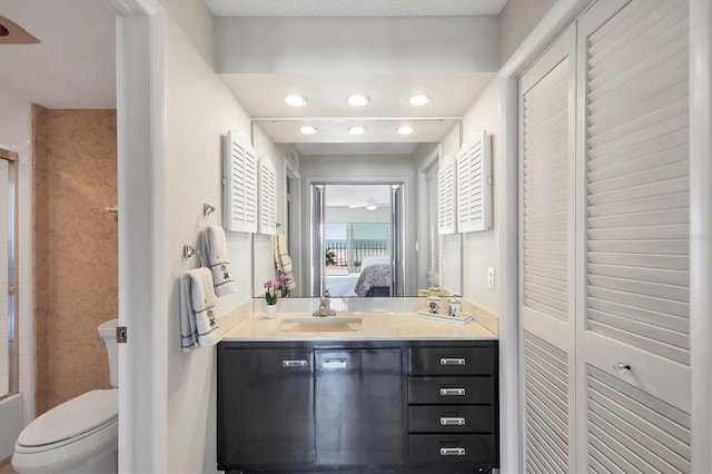 full bath featuring toilet, a ceiling fan, ensuite bath, a closet, and vanity
