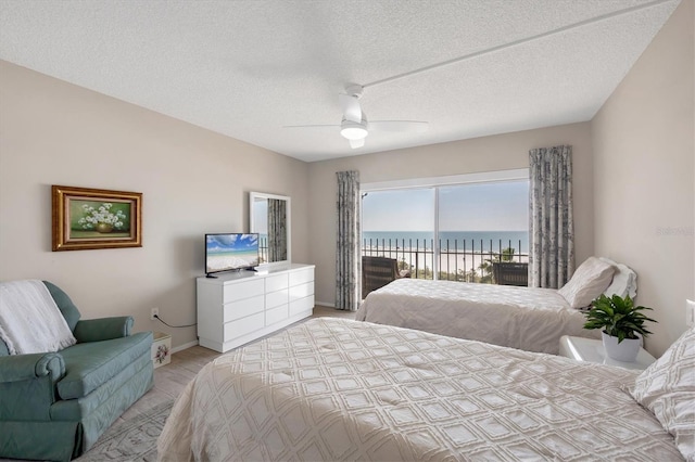 bedroom with a textured ceiling, access to outside, baseboards, and ceiling fan