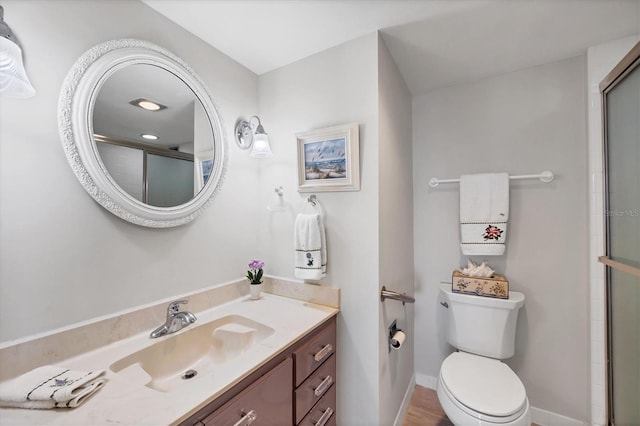 bathroom with an enclosed shower, toilet, vanity, and baseboards