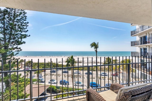 balcony featuring a water view and a view of the beach