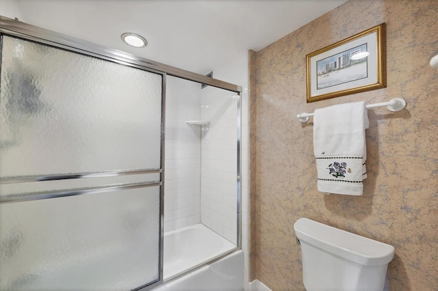 full bathroom with enclosed tub / shower combo, toilet, and wallpapered walls