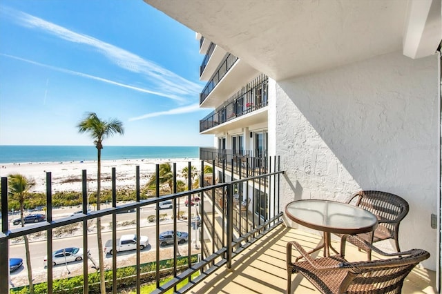 balcony featuring a water view and a view of the beach