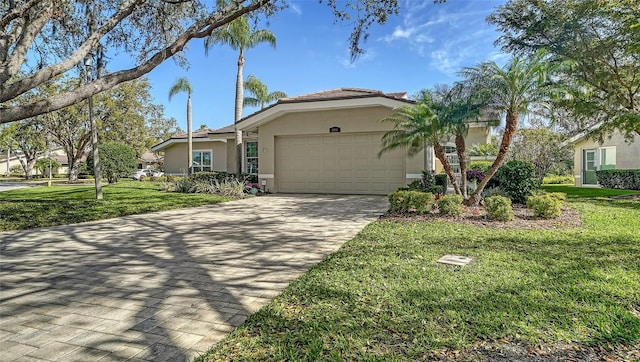 view of front of home featuring an attached garage, driveway, a front yard, and stucco siding