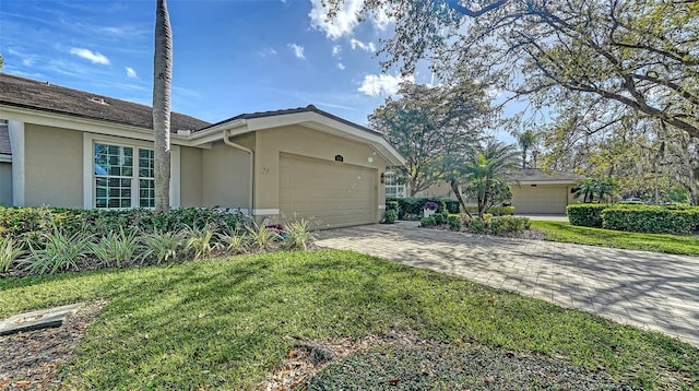 view of home's exterior featuring a yard, decorative driveway, an attached garage, and stucco siding