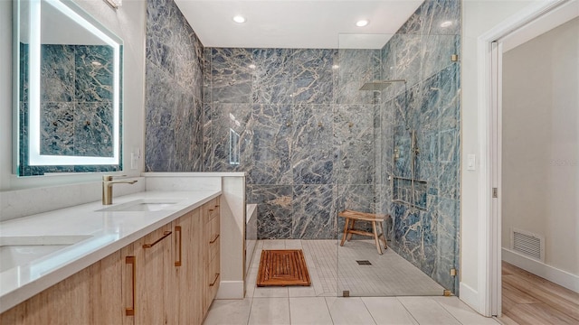 bathroom with a sink, visible vents, a marble finish shower, tile patterned floors, and double vanity