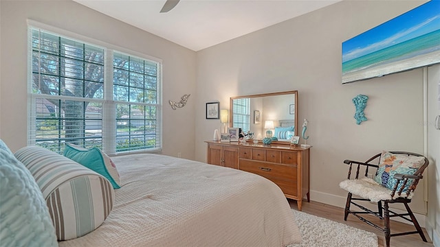 bedroom featuring ceiling fan, baseboards, and wood finished floors