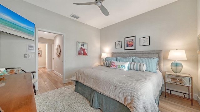 bedroom featuring a ceiling fan, wood finished floors, visible vents, and baseboards