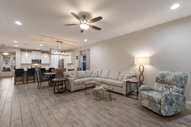 living room featuring wood finished floors, a ceiling fan, and recessed lighting