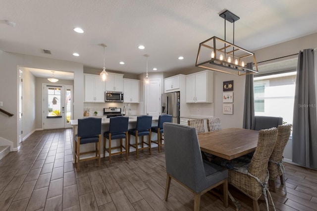 dining room with recessed lighting, visible vents, stairway, wood tiled floor, and baseboards