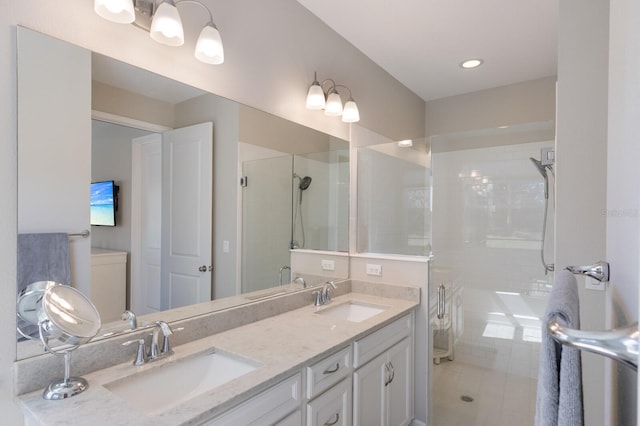 full bathroom with double vanity, a stall shower, and a sink