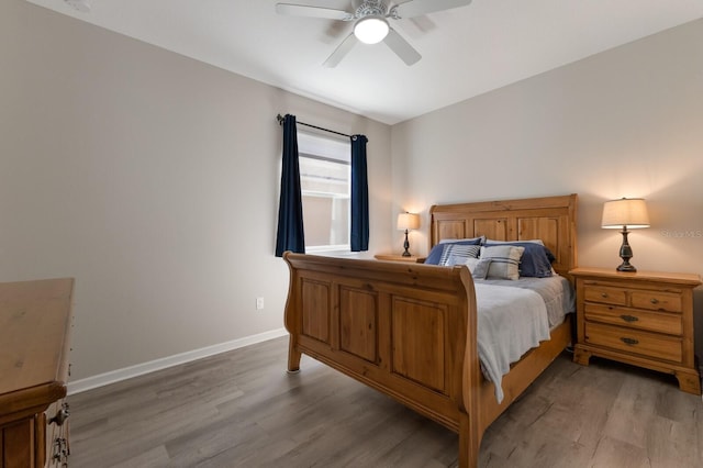 bedroom with light wood-style floors, ceiling fan, and baseboards