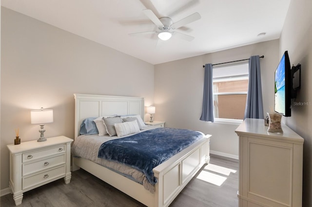 bedroom with ceiling fan, baseboards, and wood finished floors