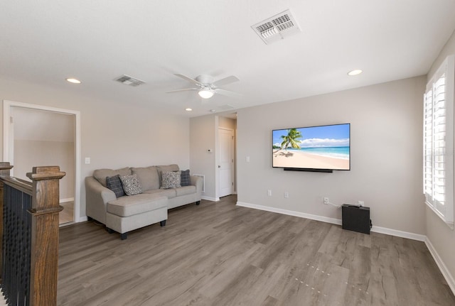 living area with recessed lighting, wood finished floors, visible vents, and baseboards