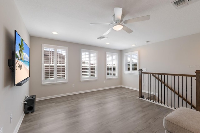 spare room with baseboards, visible vents, wood finished floors, and recessed lighting