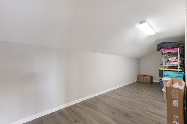 additional living space with vaulted ceiling, baseboards, and wood finished floors