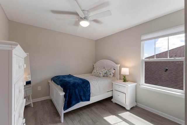 bedroom with baseboards, ceiling fan, and light wood-style floors