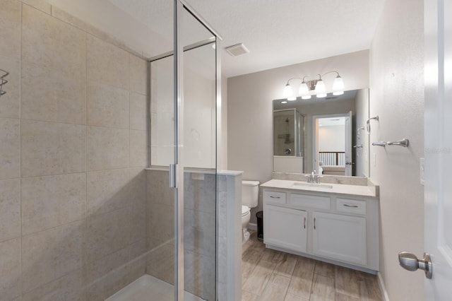 bathroom featuring a stall shower, visible vents, vanity, and toilet