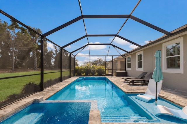 view of swimming pool with glass enclosure, a pool with connected hot tub, and a patio area