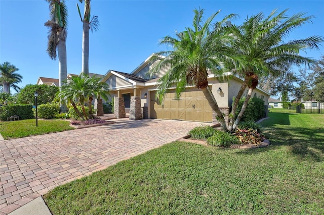 view of front of home featuring an attached garage, decorative driveway, a front yard, and stucco siding