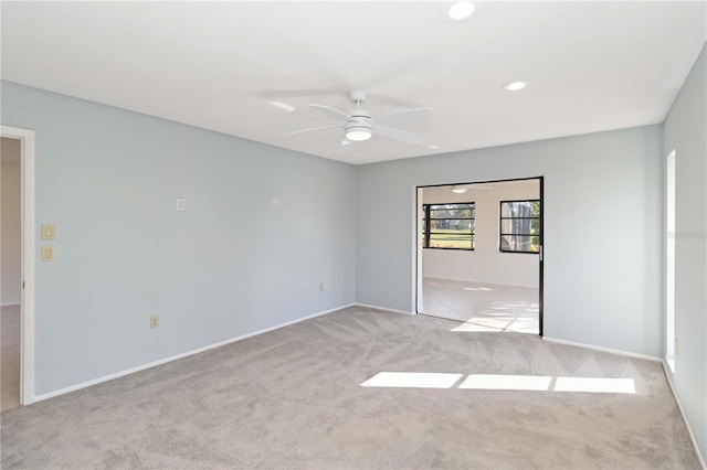 empty room with carpet floors, recessed lighting, ceiling fan, and baseboards