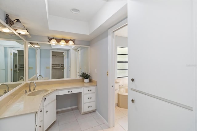 full bathroom with baseboards, a raised ceiling, tile patterned floors, vanity, and a bath