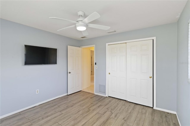 unfurnished bedroom with a closet, visible vents, light wood-style flooring, and baseboards